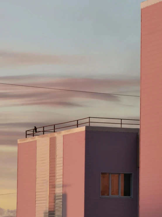 pink building and sky line with one person standing on one corner