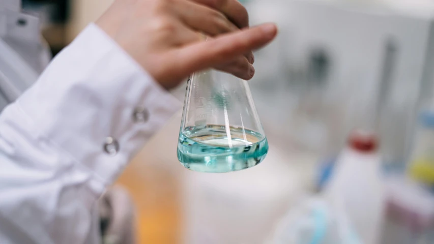 a hand holding a flask filled with water