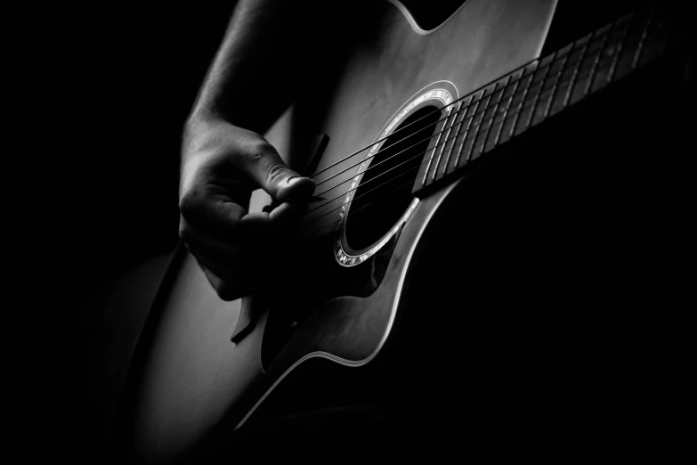 a person playing a guitar in black and white