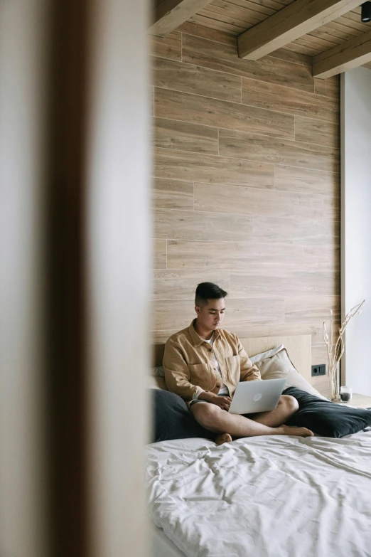 a man sitting on his bed reading a book