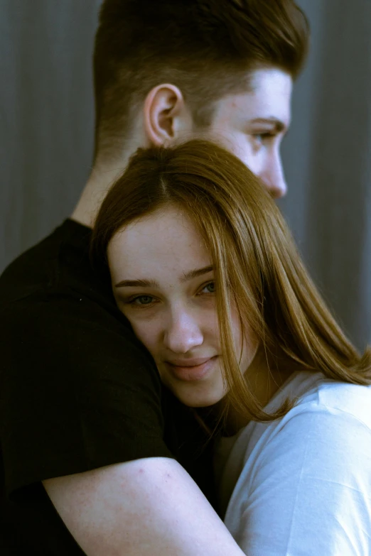 a couple of young people emcing in front of a window