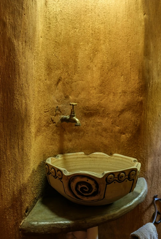 a bathroom sink sitting under a faucet in a room