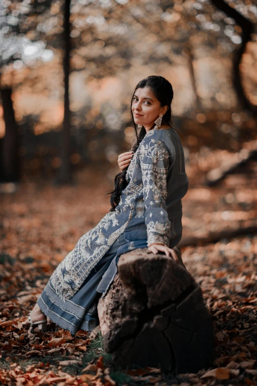 a woman standing in the woods while holding an umbrella