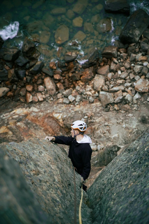 a person climbing up the side of a rock
