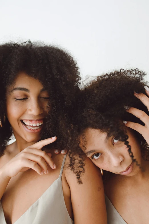 two women smiling with their hands on their backs