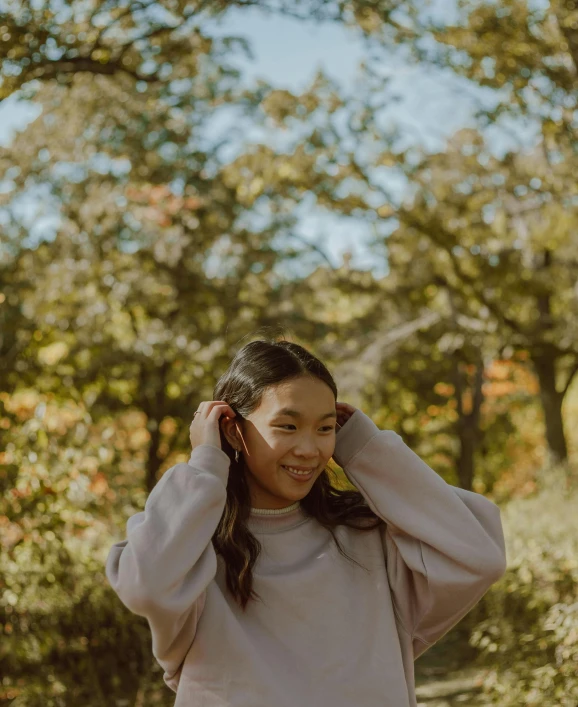 a young woman holding her head in the woods