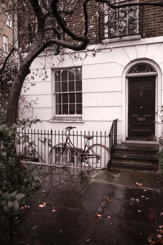 there is a bicycle propped against the fence on this street