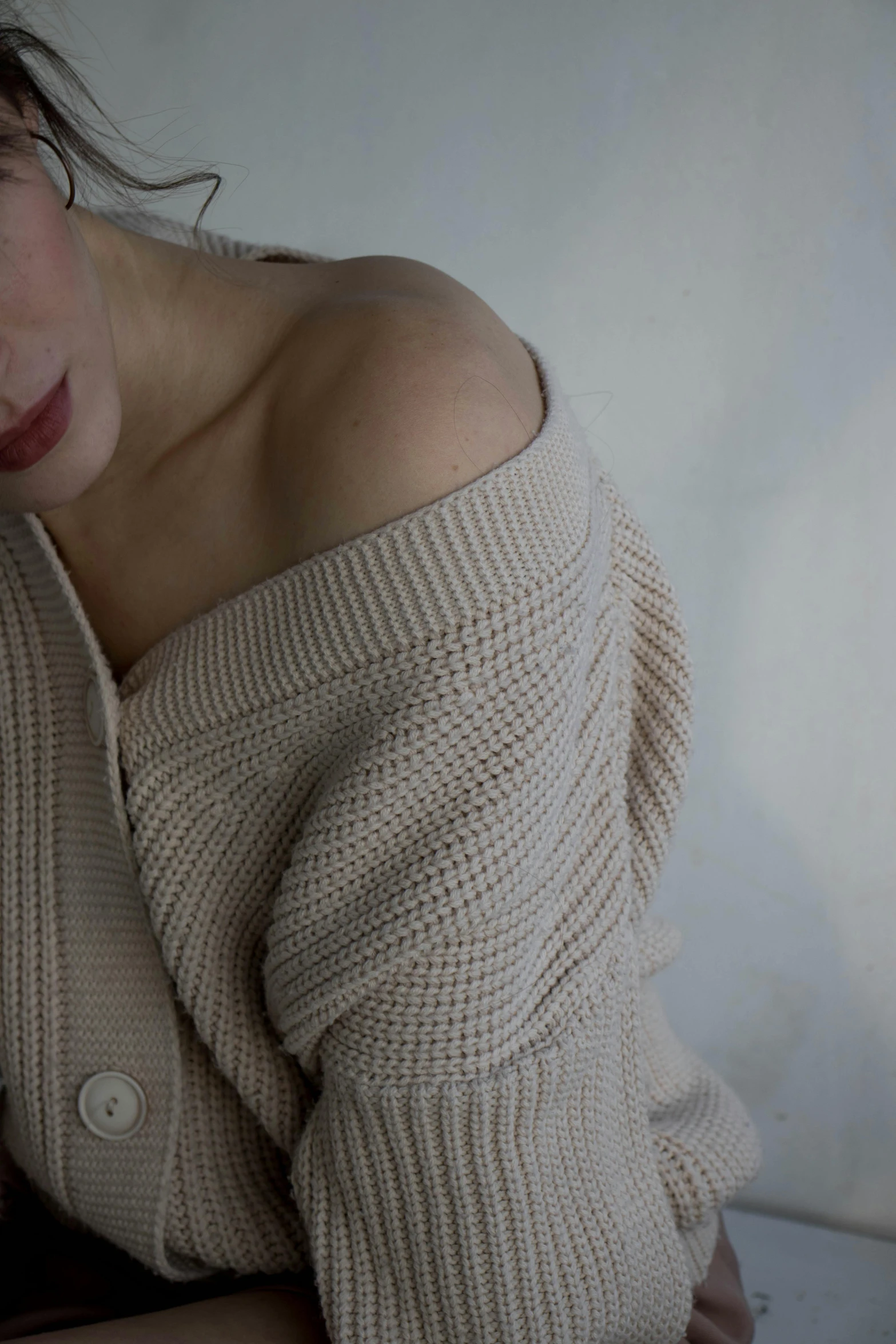 a women is sitting down wearing a sweater