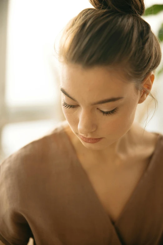 young woman in brown top writing on her cellphone