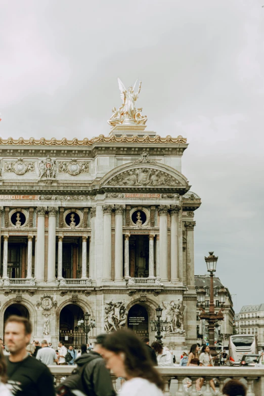 an ornate building with two towers and people walking around it