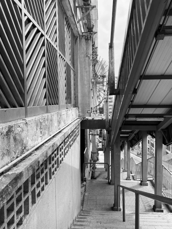 a walkway in black and white with a bench on the side