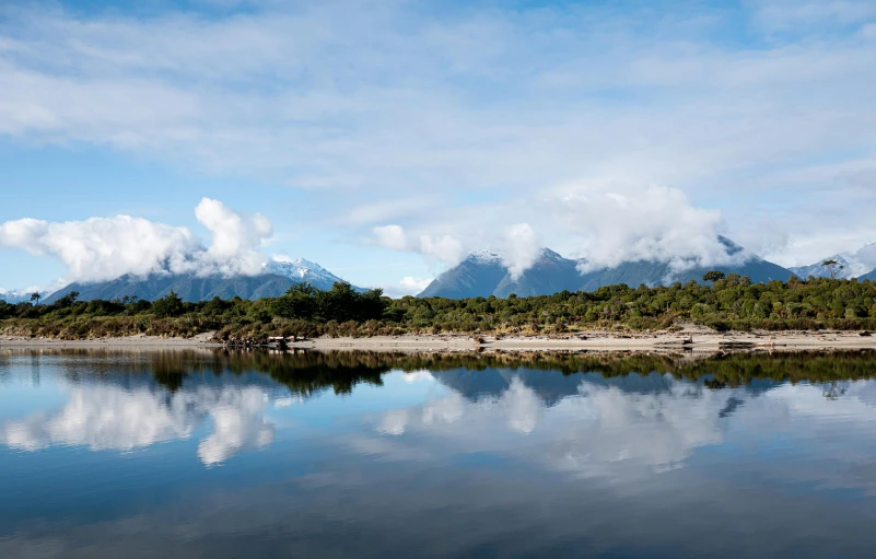 trees and hills with sky reflected in the water