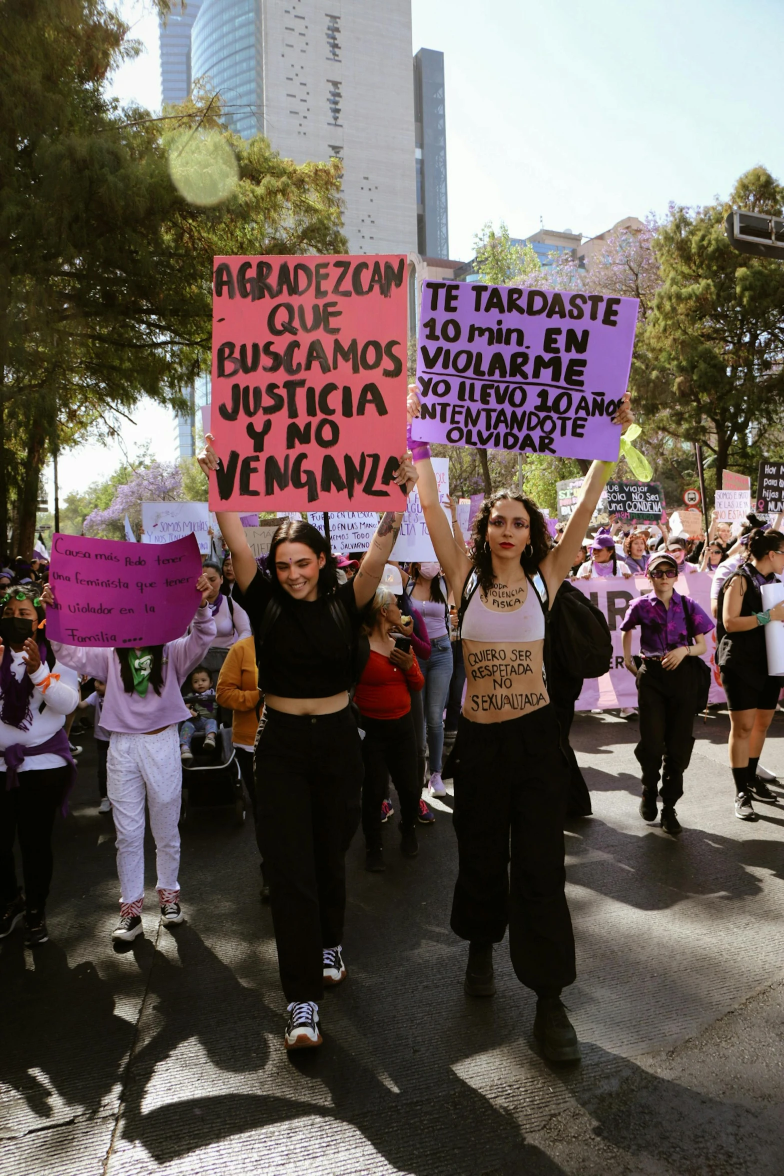 people protesting in a city area holding signs