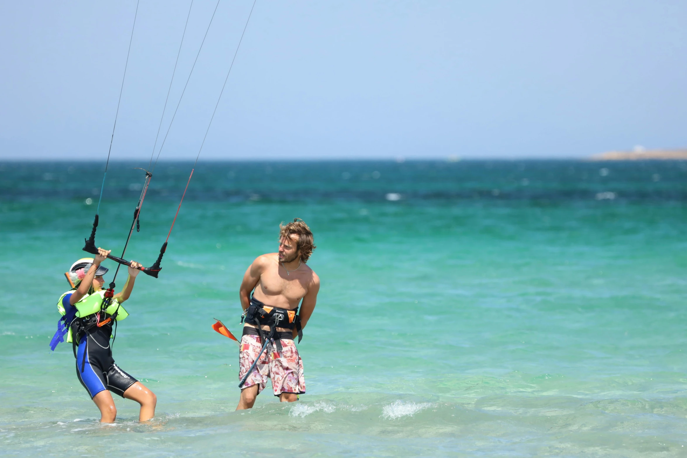 two people in the ocean water holding a kite