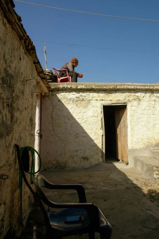 a chair and a man sitting in an alleyway