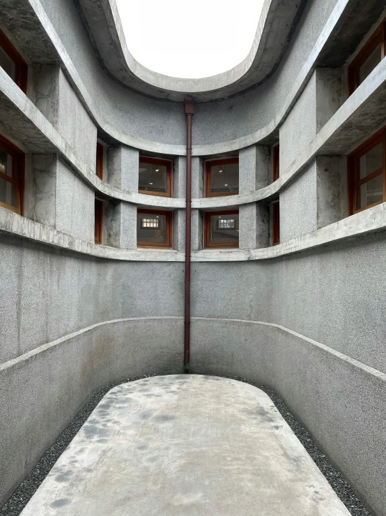 an empty room with multiple stories, windows and a concrete floor