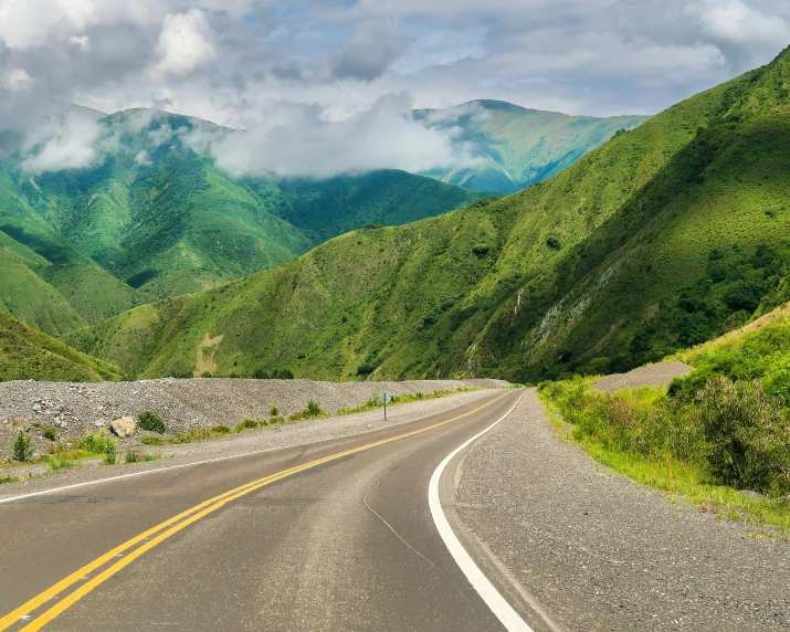 an empty road on the side of the mountain