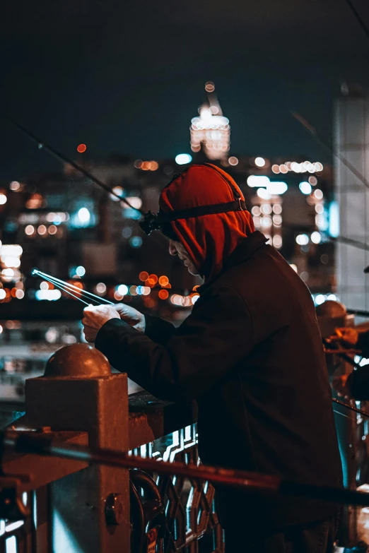 man in hoody standing on top of a building