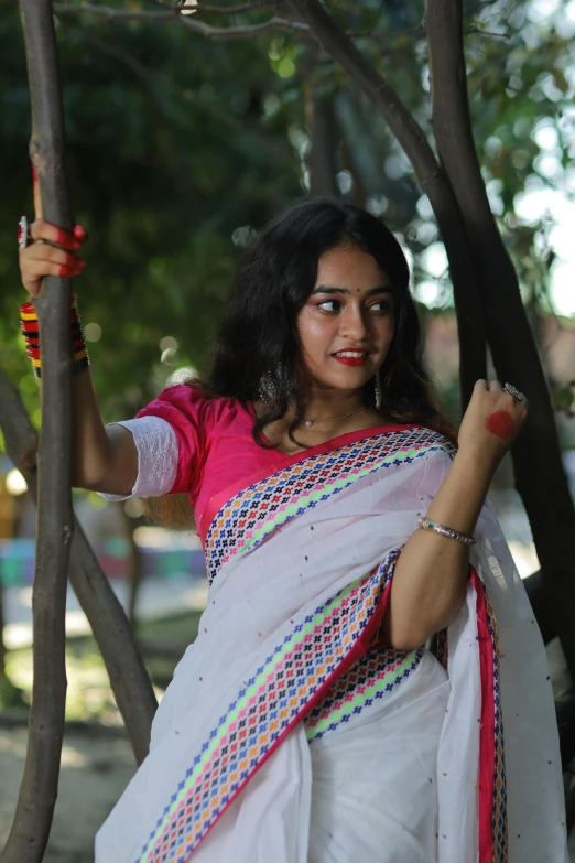 a woman in a white sari holding a plant