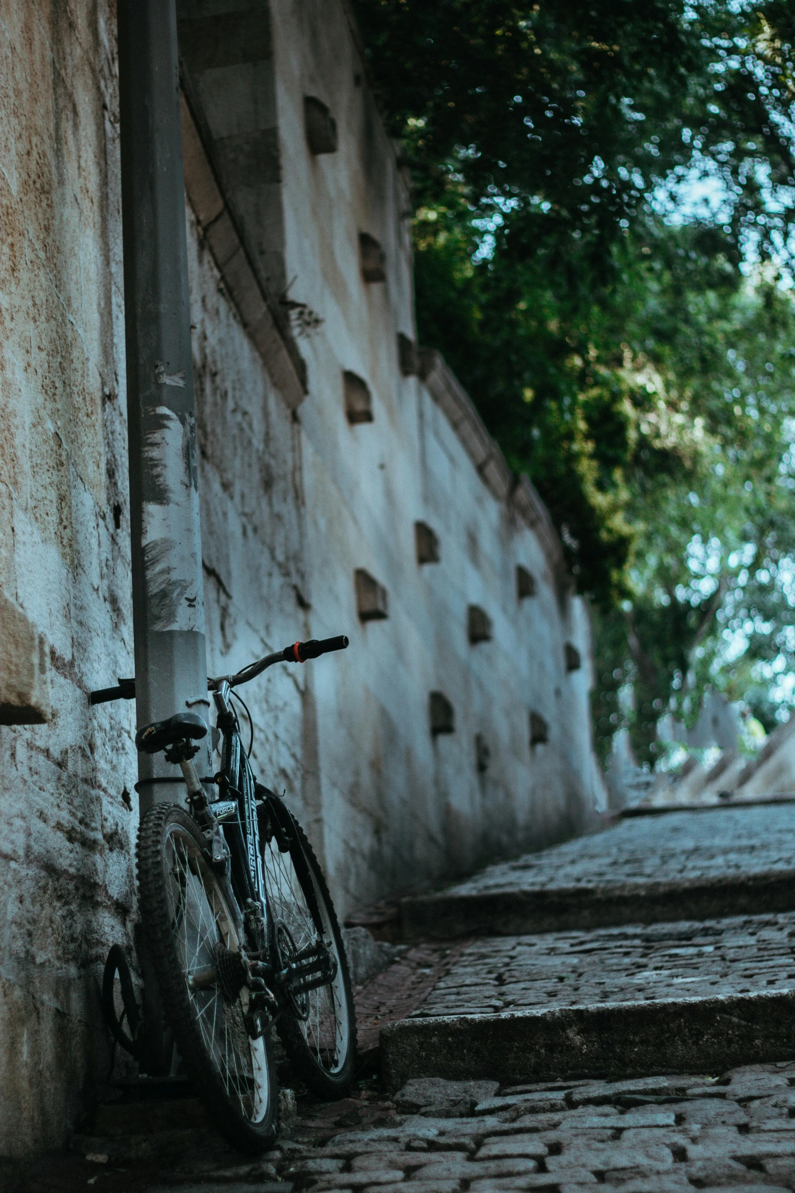 a bicycle rests on the brick wall next to the stairs