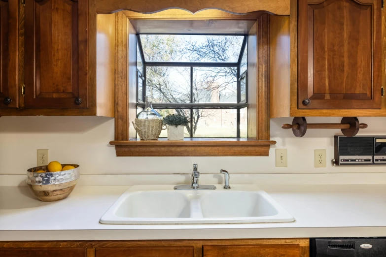 a white sink next to a window in a kitchen