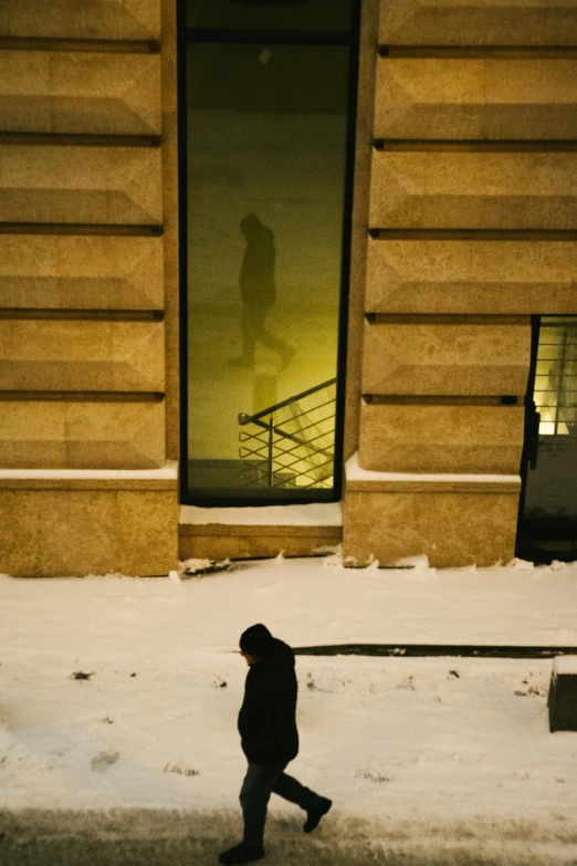 a man walks down the street in the snow