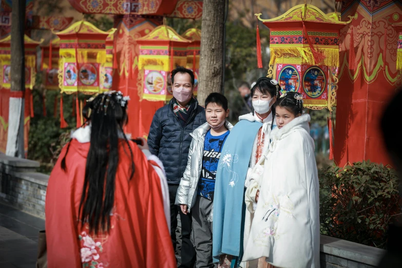 people are wearing masks in front of a chinese arch