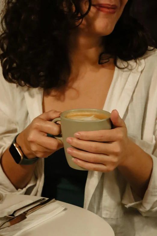 a woman is holding a coffee cup in her hands