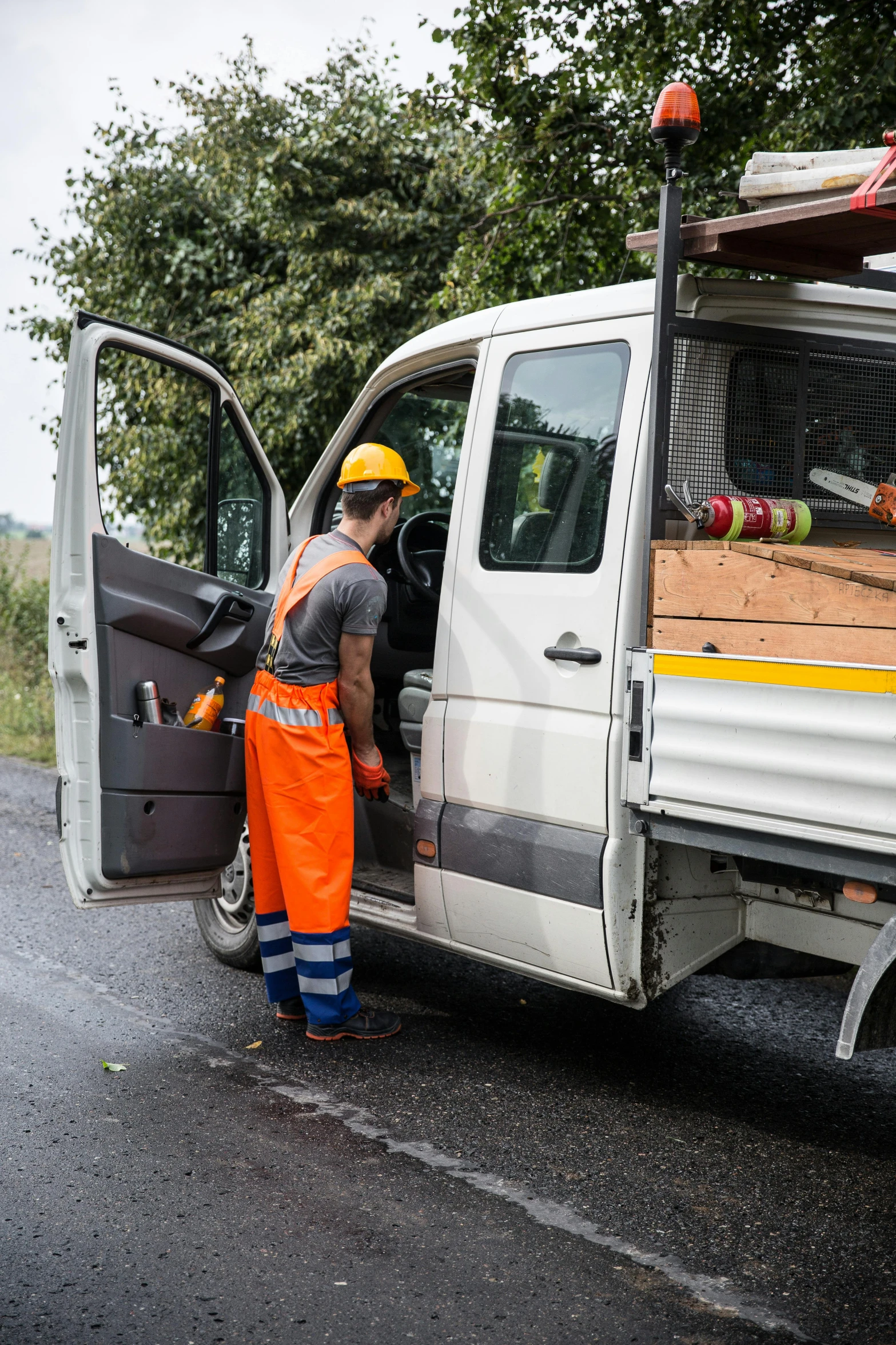 a man in orange pants and safety helmet is loading the back of a truck