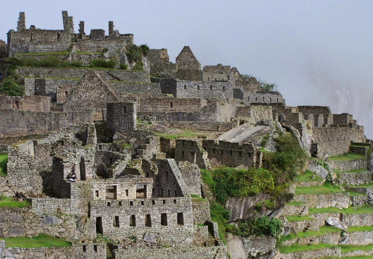 a pile of old stone buildings sitting on top of a hill