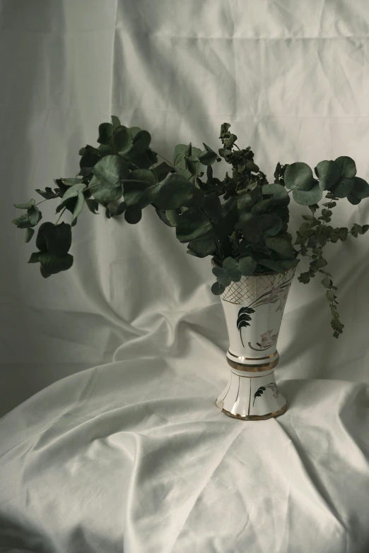 an assortment of leaves in a white vase