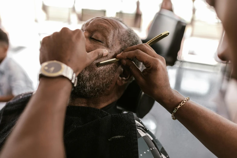 a man getting his hair cut with two scissors