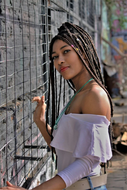 an indian woman wearing a white top and dreadlocks