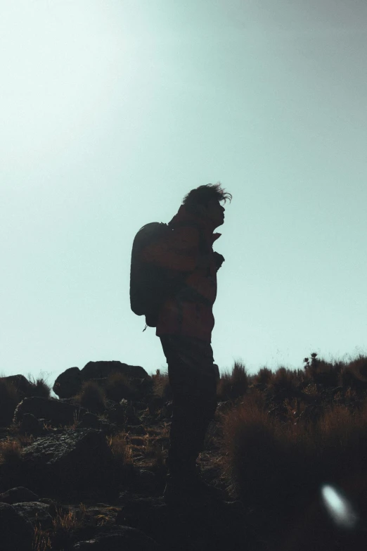 a person standing on a hill with a cell phone in his hand