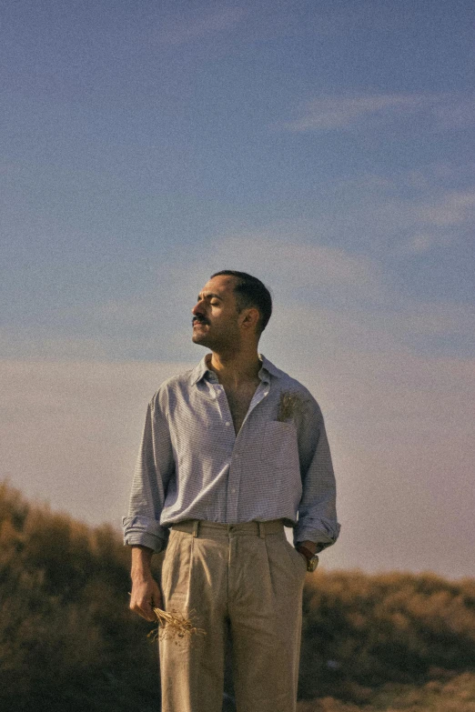 a man with a suitcase standing outside against the sky