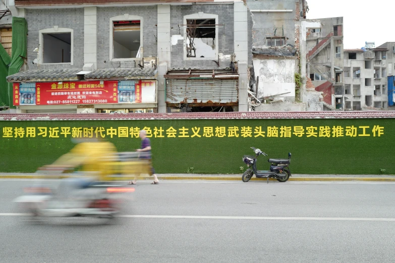 two people on motorcycles riding near a damaged building