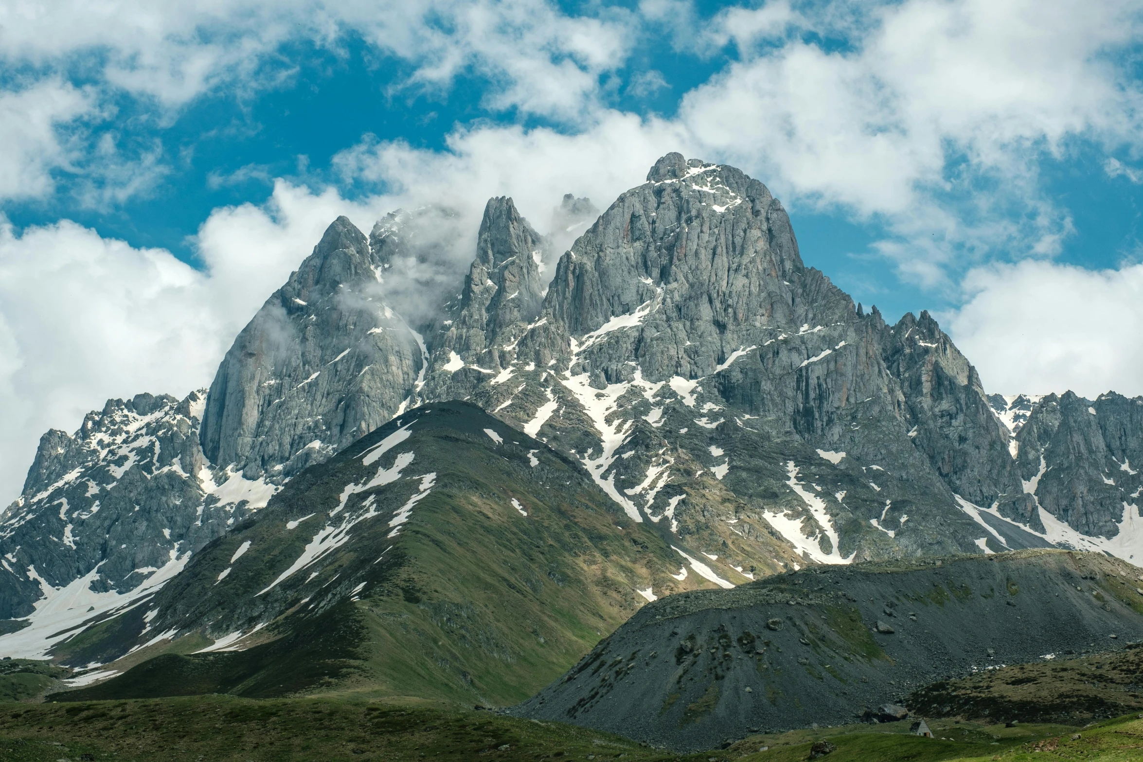 an enormous snow covered mountain rises into the clouds