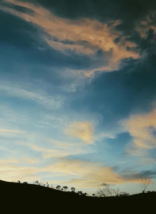 the silhouette of a person with his arms out to catch a frisbee