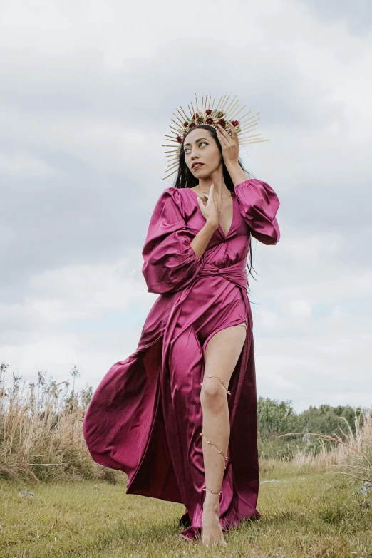 woman in purple dress walking through grassy field