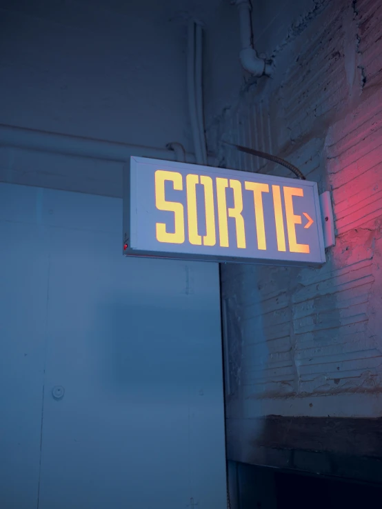 a large white and yellow electronic sign hangs over a doorway