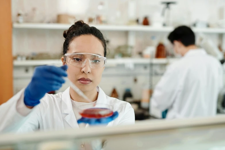 woman looking at a laboratory sample in front of a microscope