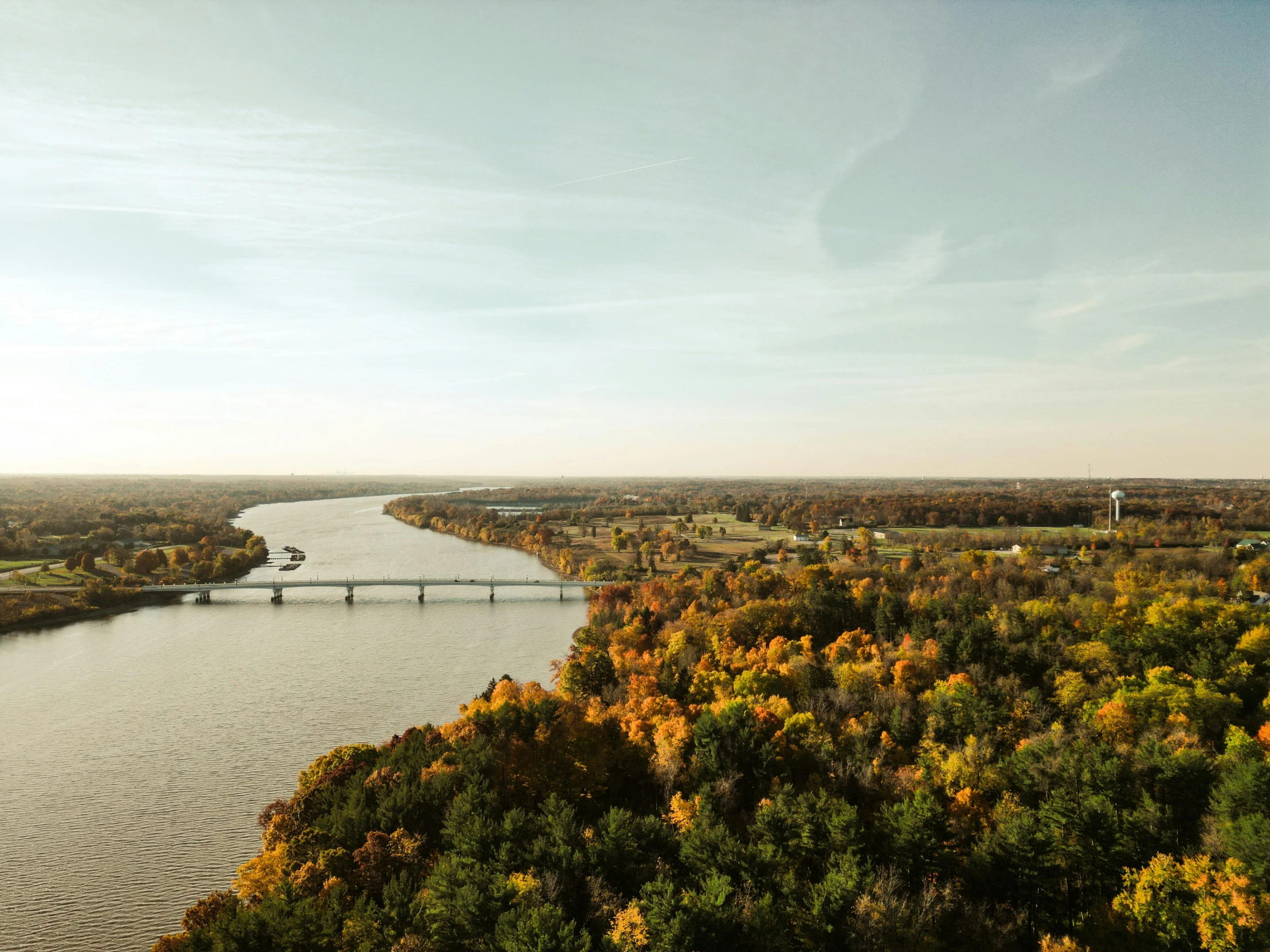 a bridge across a river in an area with trees in front of it