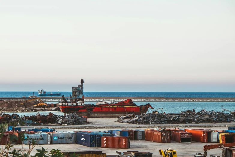 there are a lot of small containers with a ship in the background