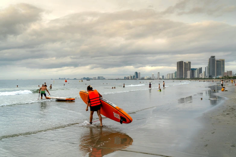 a group of people standing on top of a beach holding surfboards