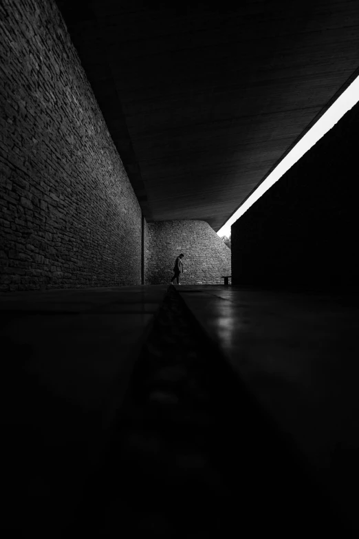 the silhouette of a person standing next to a wall with a long shadow