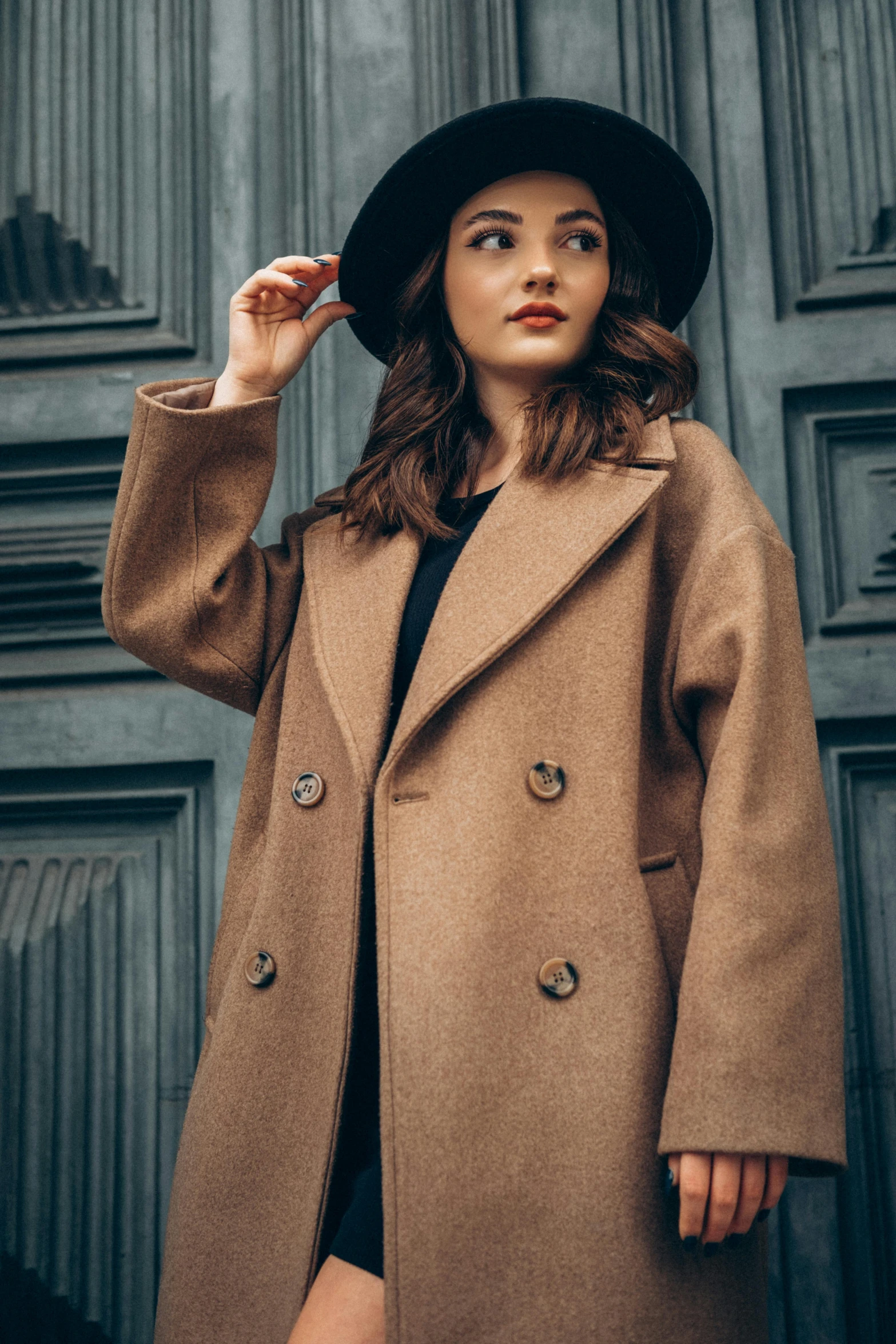 a woman wearing a brown trench coat posing