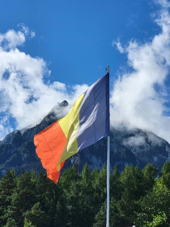 a large white and yellow flag flies in the wind