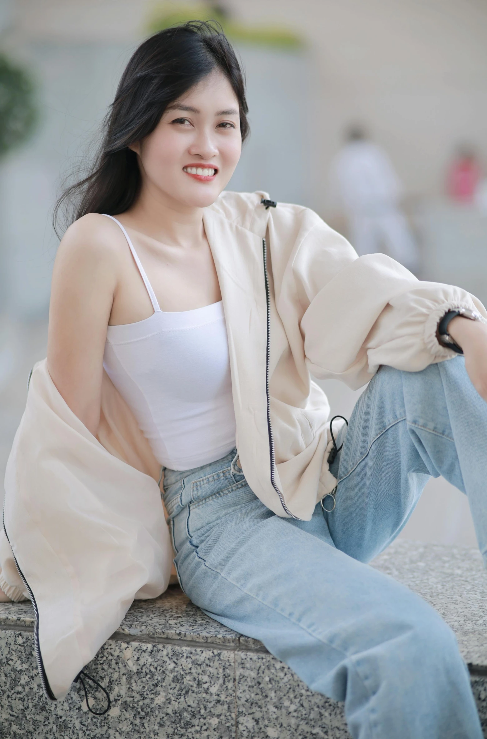 a woman in white top and jeans posing with jacket