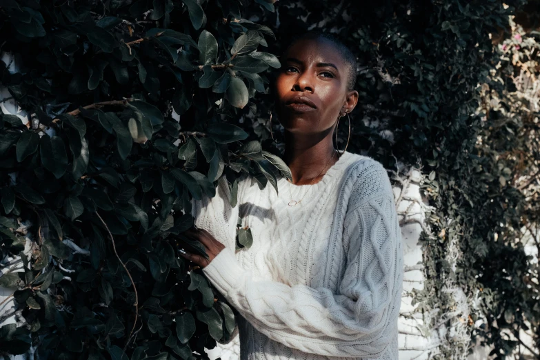 a woman standing in front of some leaves