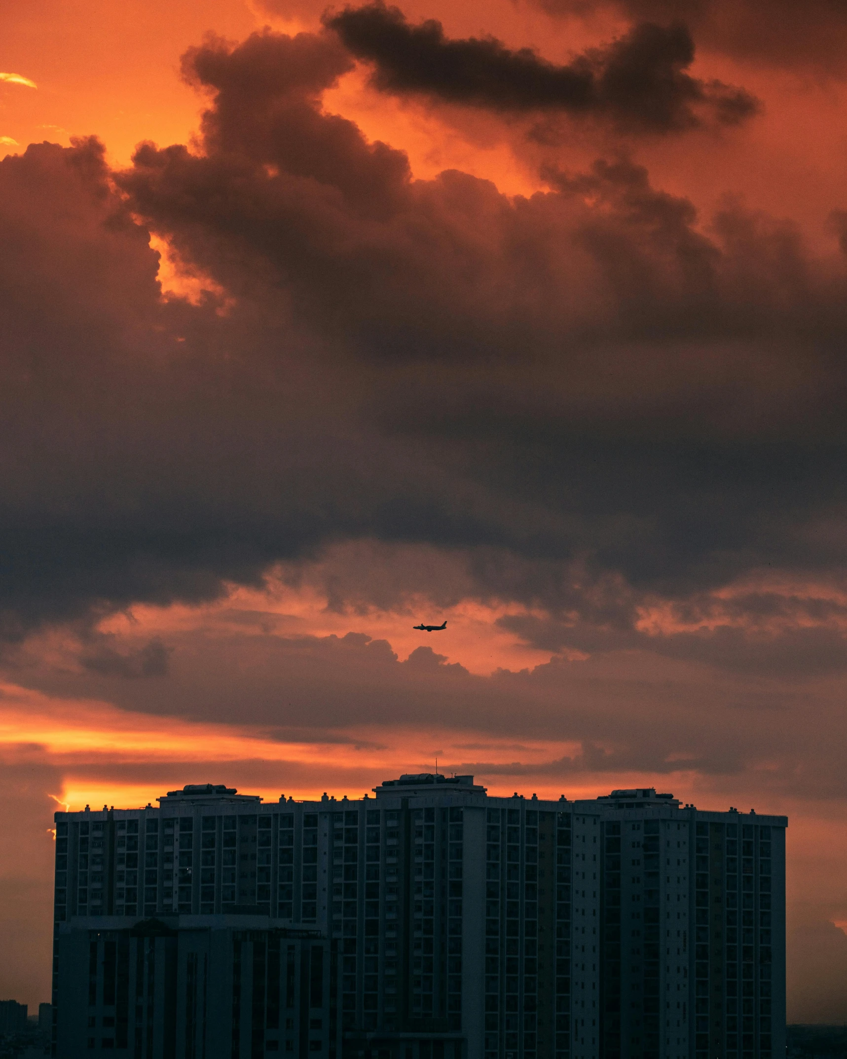 clouds and airplane above building in urban setting